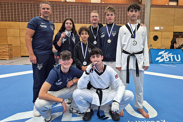 Taekwondo-Teamfoto mit Jugendlichen und Trainer